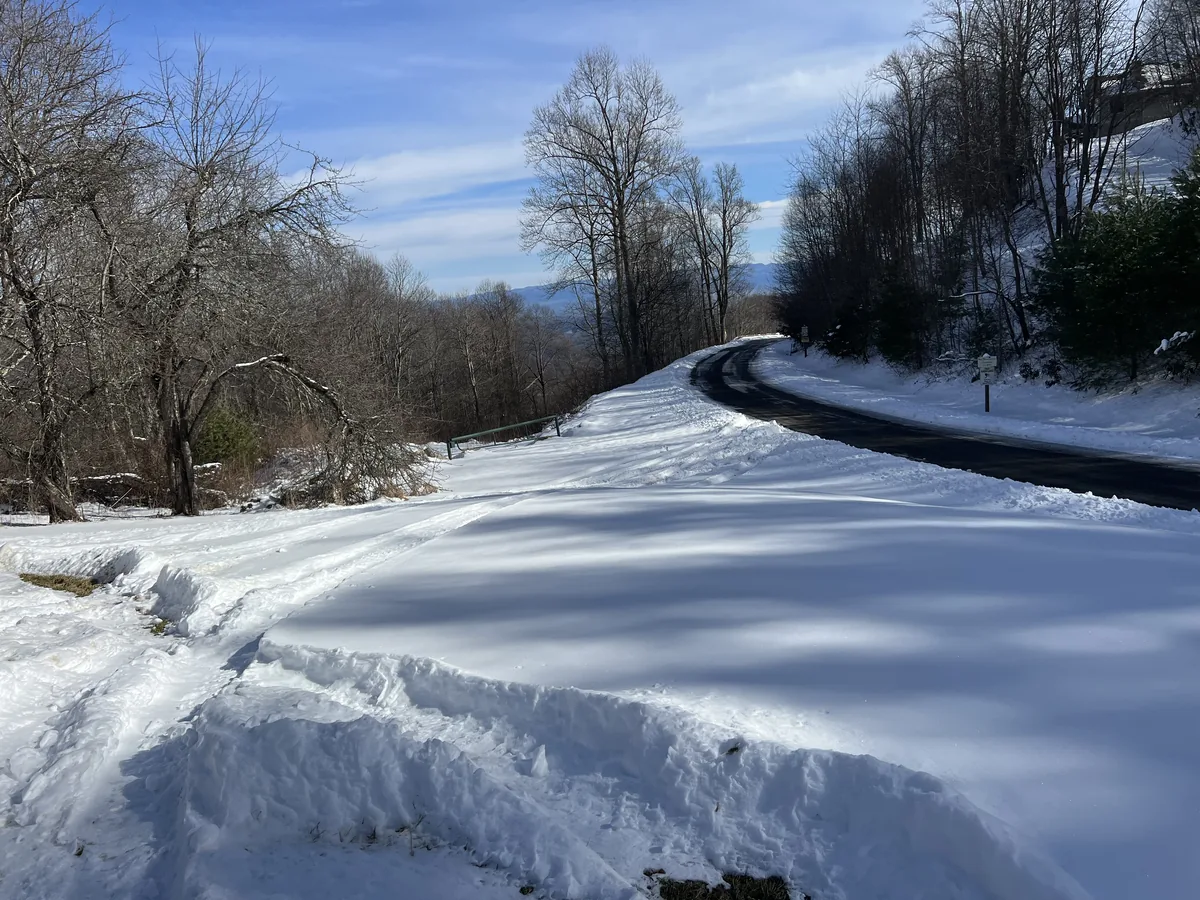 Snow covering a curving mountain drive in Haywood County