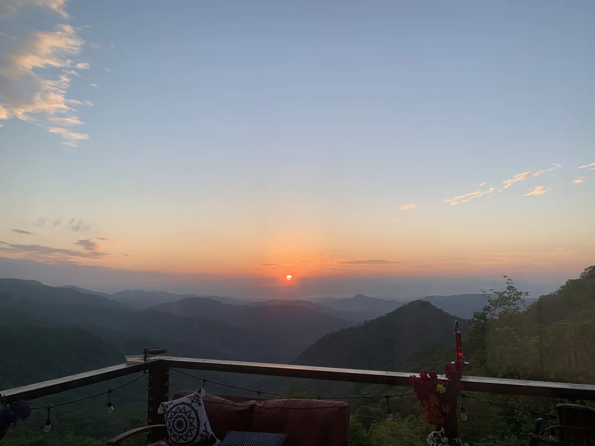 A warm sunrise over layered mountain ridges in western North Carolina